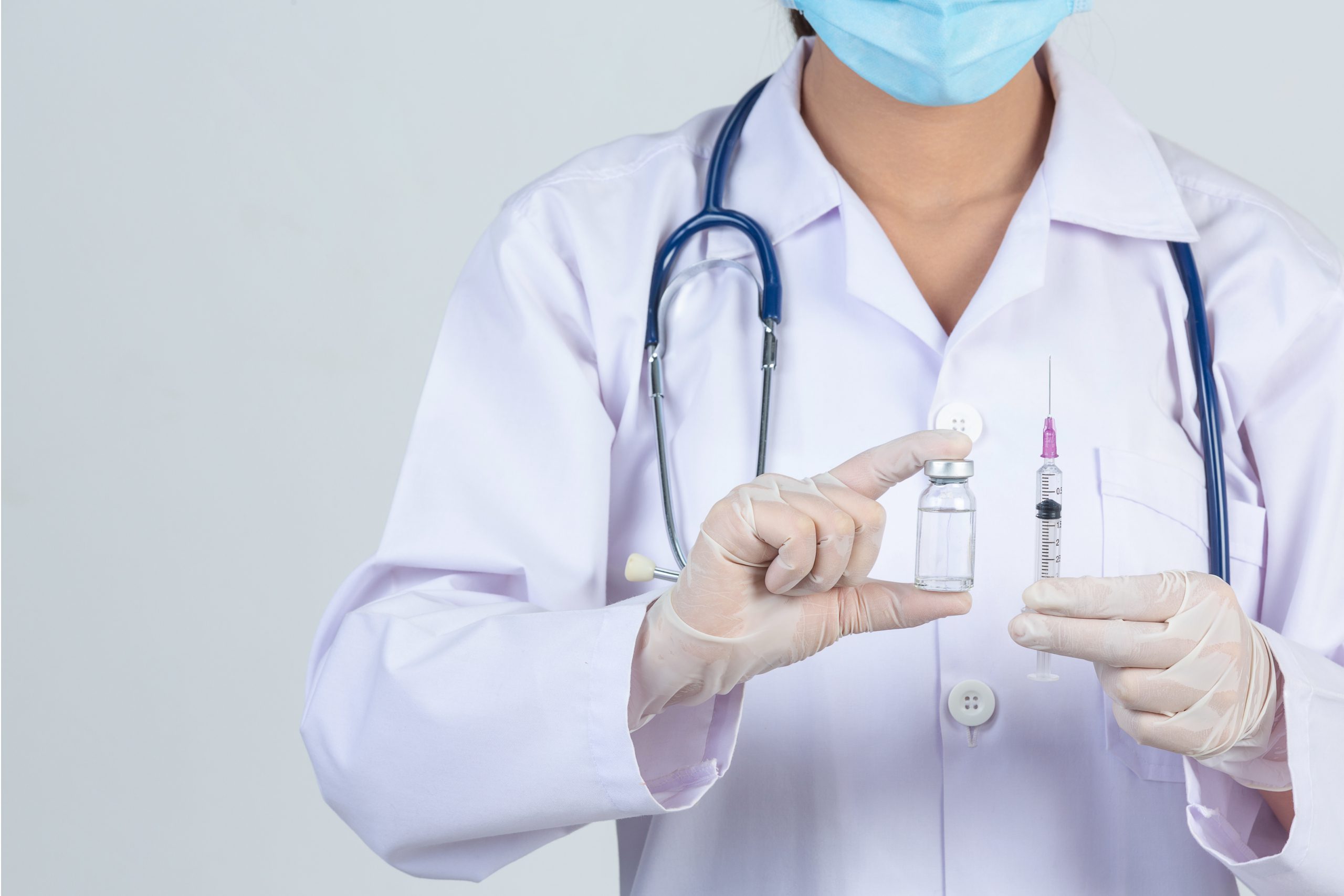 Doctor holding vaccination needle and solution - flu