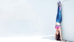 woman doing hand stand athleisure trends