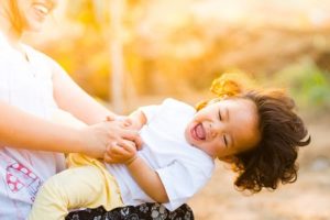 minimalist parent spending time with kids playing and laughing without tangable items