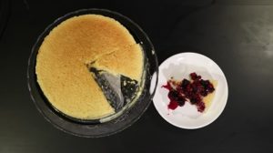 Japanese Cotton Cheesecake - full cake with a slice and berries on top
