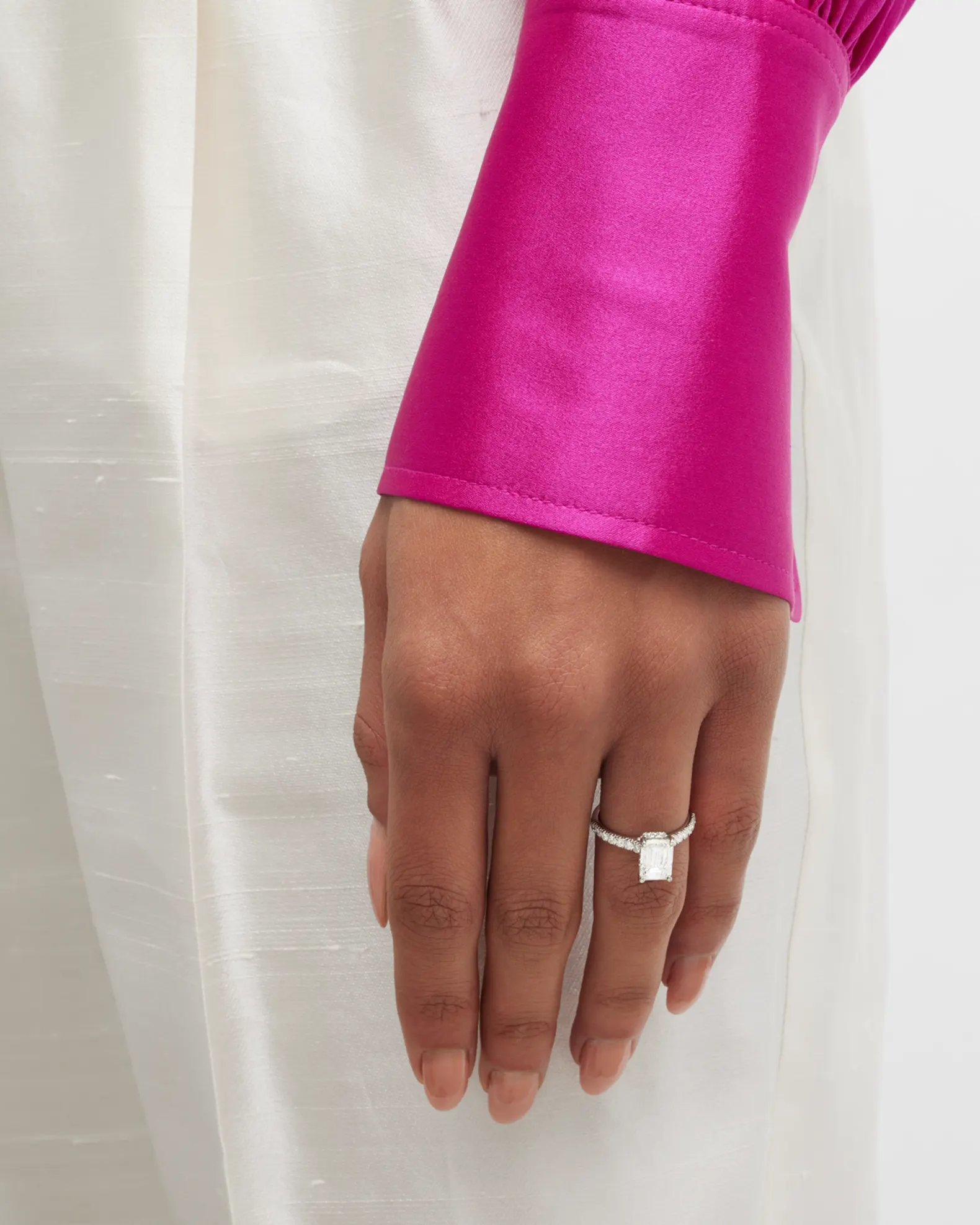 Hand wearing diamond ring, pink sleeve