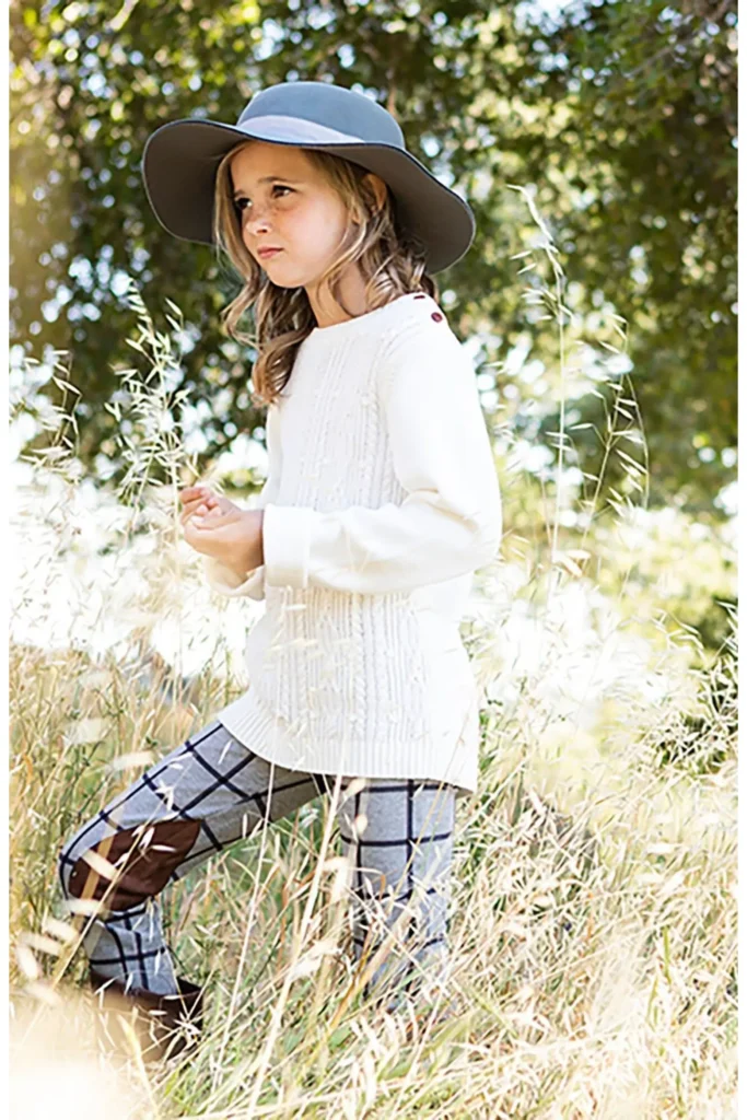 Girl in sweater and hat outdoors back to school outfits for girls