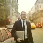 Determined smiling businessman with laptop on street - how to build your personal brand