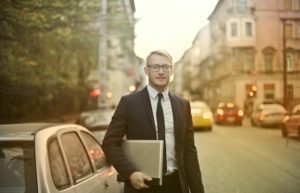 Determined smiling businessman with laptop on street - how to build your personal brand