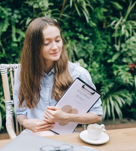 A Woman Sitting while Holding a Clipboard - how to build your personal brand