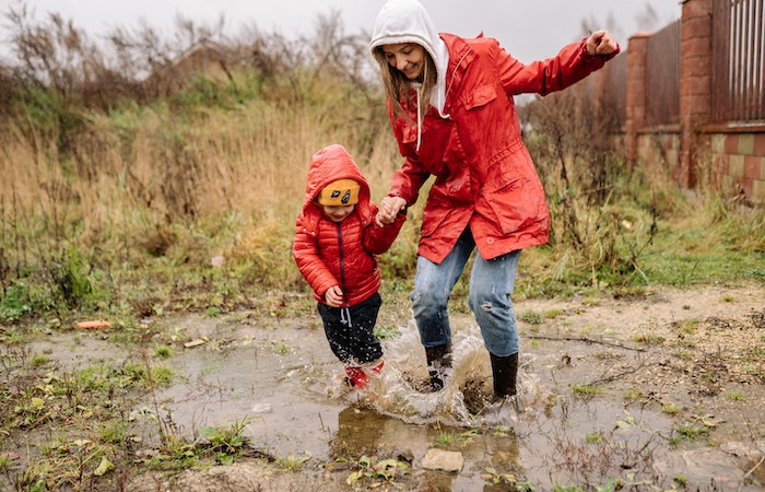 A Woman Playing on the Rain with Her Child - rain clothes for kids