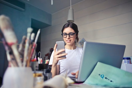 Woman in White T-shirt Holding Smartphone in Front of Laptop - how to get interns
