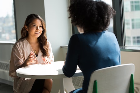 Woman in White T-shirt Holding Smartphone in Front of Laptop - how to get interns