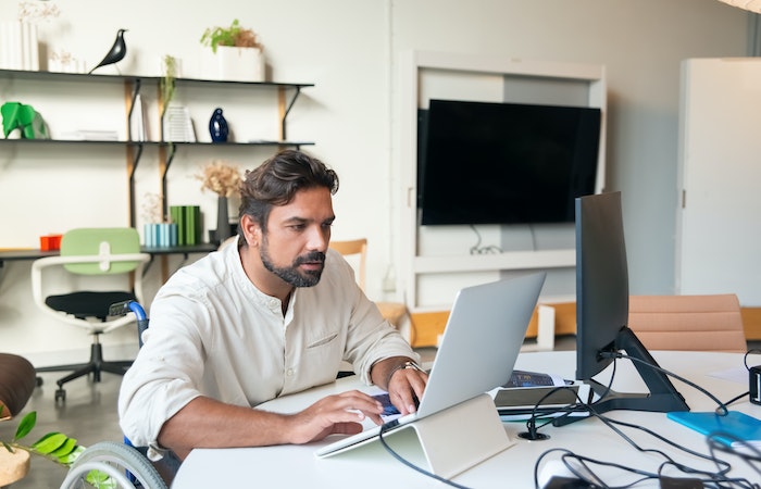 Man in white shirt at MacBook- temp agencies