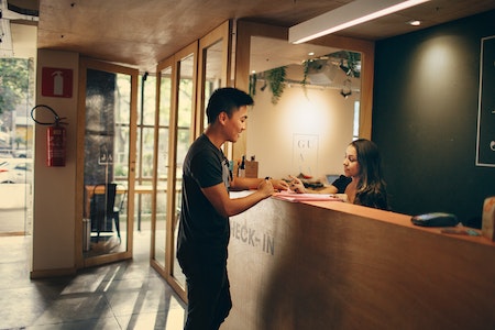 Man Standing in Front of Front Desk - part time receptionist jobs