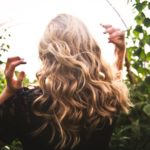 Blonde-haired Woman Standing Between Green Plants - easy Christmas hairstyles
