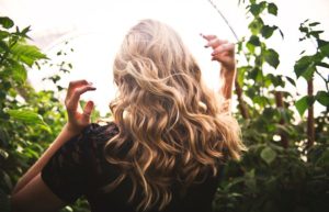 Blonde-haired Woman Standing Between Green Plants - easy Christmas hairstyles