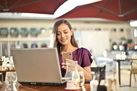 Woman Wearing Purple Shirt Holding Smartphone White Sitting on Chair - remote nonprofit jobs