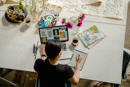 Photo of Woman Writing on Tablet Computer While Using Laptop - creative jobs near me