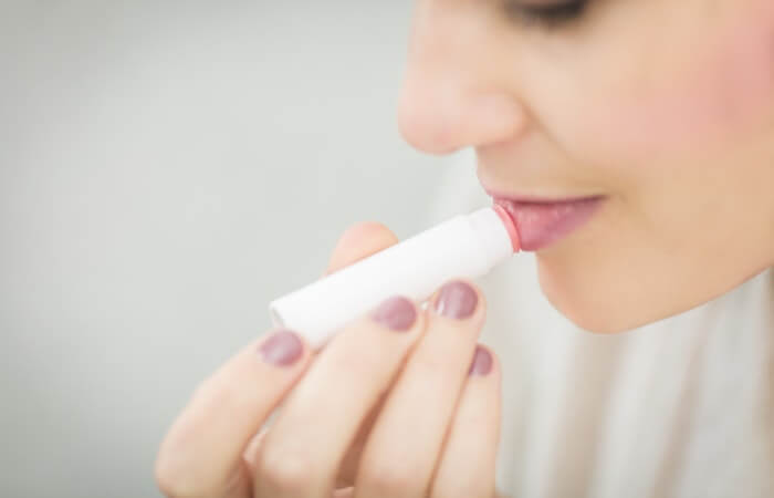 Woman Putting Lipstick - winter fresh sugar lip balm