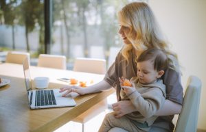 Woman Carrying her Baby and Working on a Laptop - work from home outfits