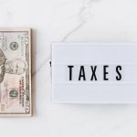 American dollar bills and vintage light box with inscription - tax prep for small business