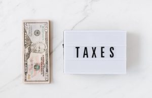 American dollar bills and vintage light box with inscription - tax prep for small business