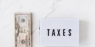 American dollar bills and vintage light box with inscription - tax prep for small business