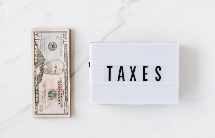 American dollar bills and vintage light box with inscription - tax prep for small business