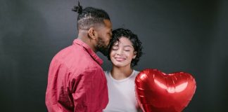 Man Kissing His Woman While Holding a Red Heart Shaped Balloon - best Valentine's Day jewelry deals