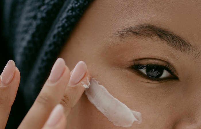 Woman applying Facial Cream on Face - best drugstore eye cream