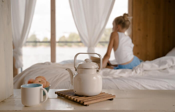 Young Girl Sitting on Bed with Breakfast on Table - birth control near me