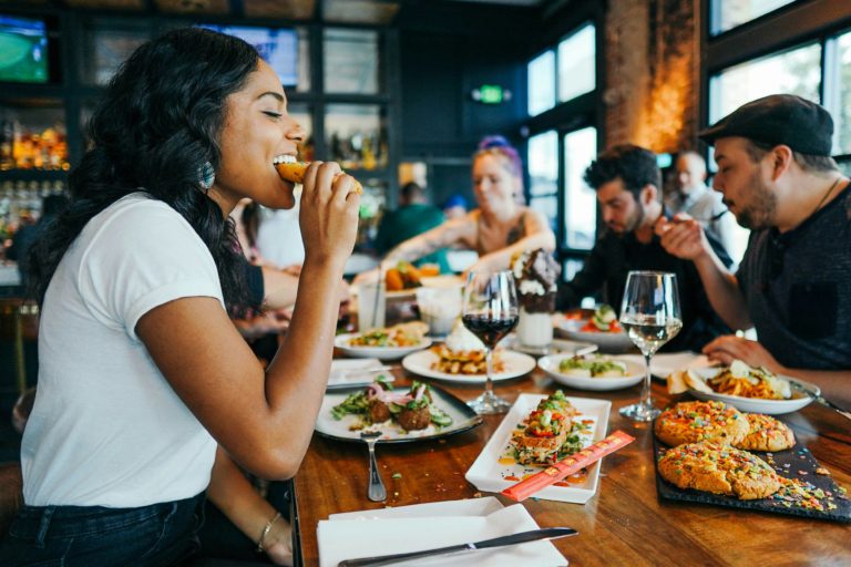 gastronomic getaways - woman eating at restaurant