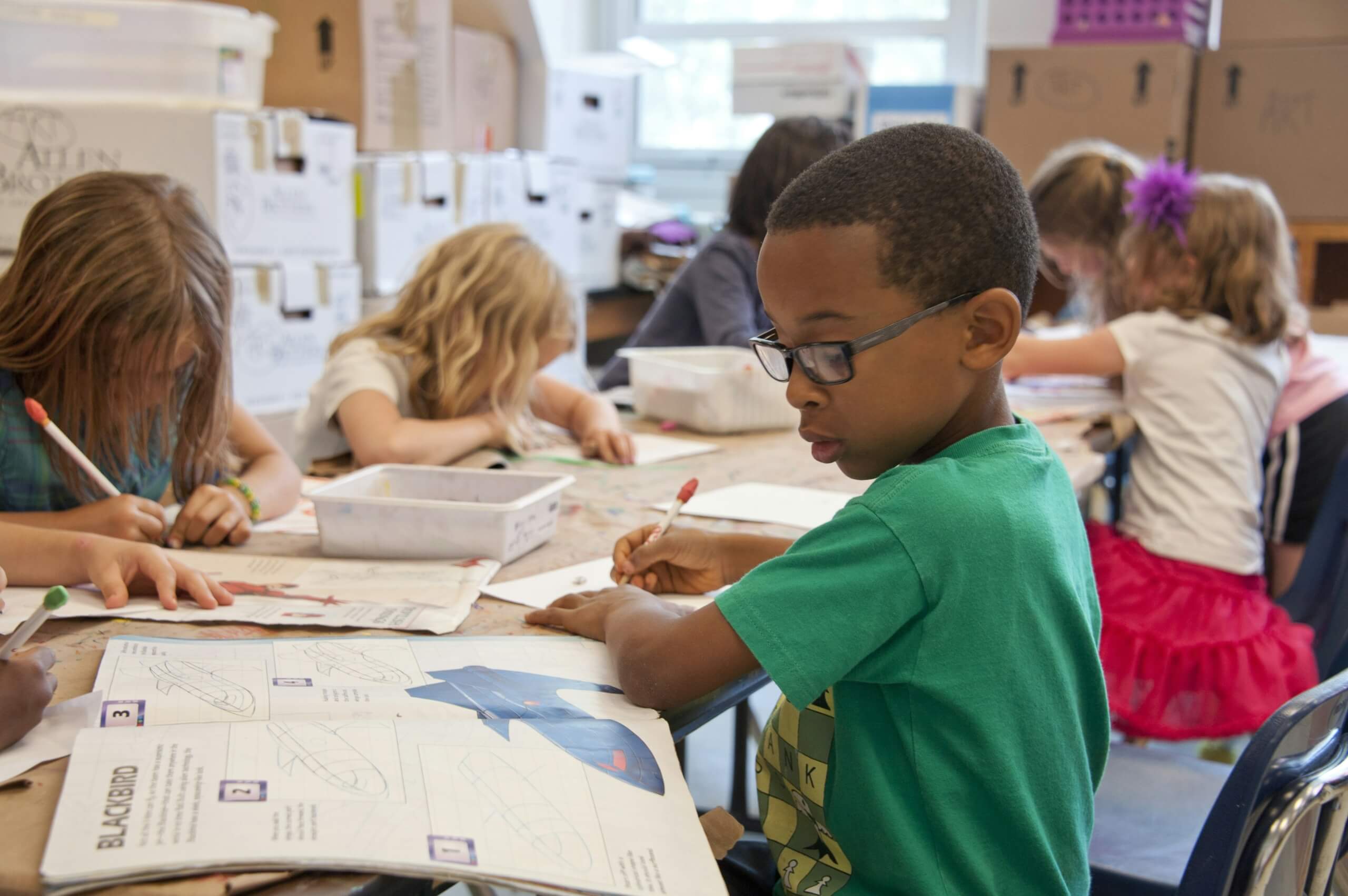 back to school supplies - kids in classroom writing