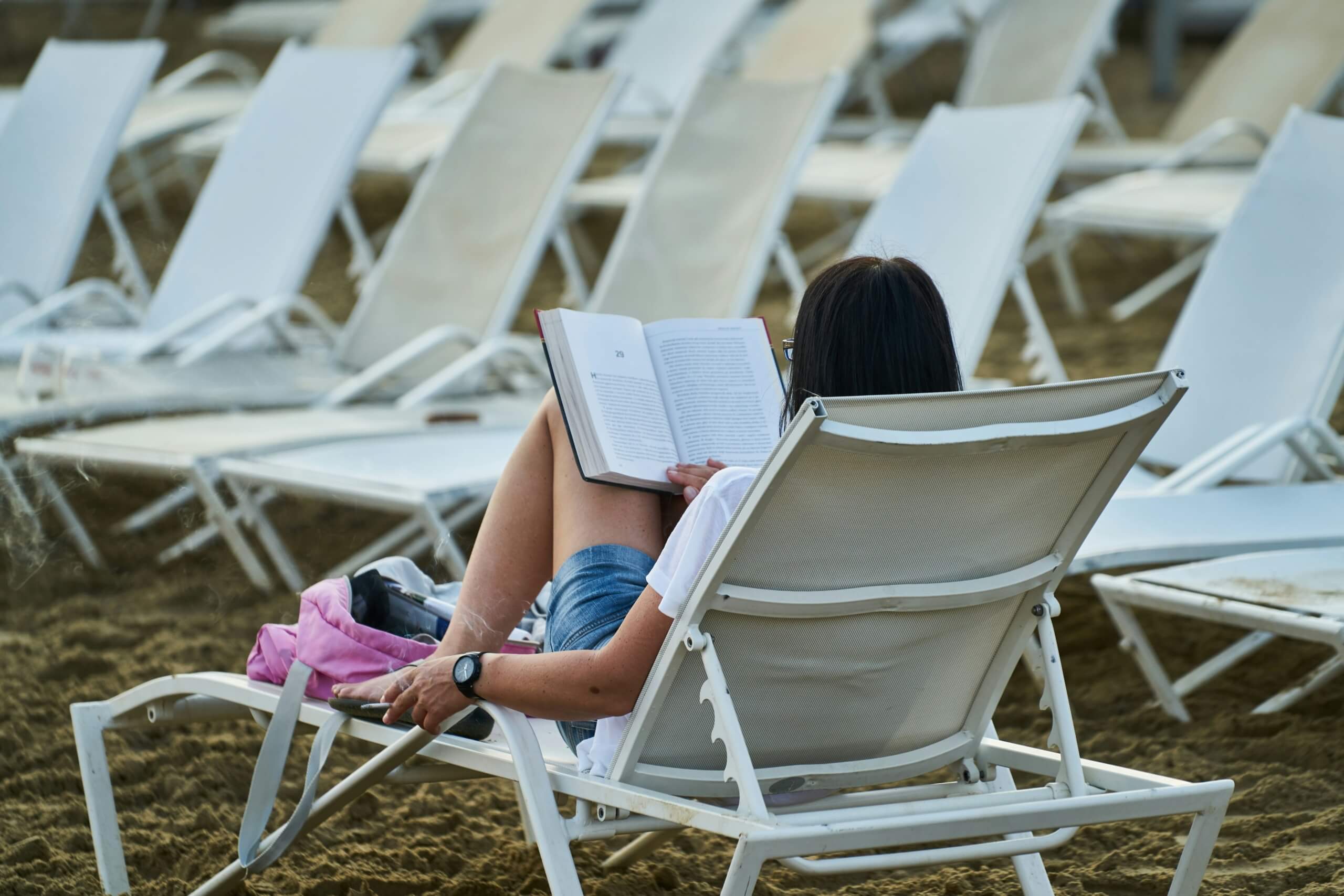 solo trips for women - woman reading on the beach