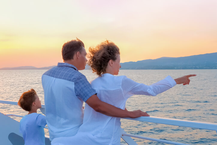 Happy family travels by sea. Family tourism concept. Consumers pinpoint travel. Voyage to Greece. Season stay, short stay of traveling. Woman in white with husband and son on yacht, boat, ship national plan a cruise month