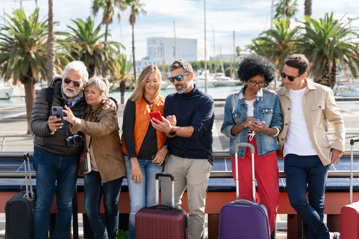 Group of tourists using cell phones in the city - Family friends traveling with smartphone app national plan a cruise month