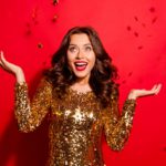 Careless, carefree, dream, dreamy concept. Photo of stylish, trendy modern lady with wave hairstyle isolated on bright red background raised hands up rest, relax on December night party christmas party dress